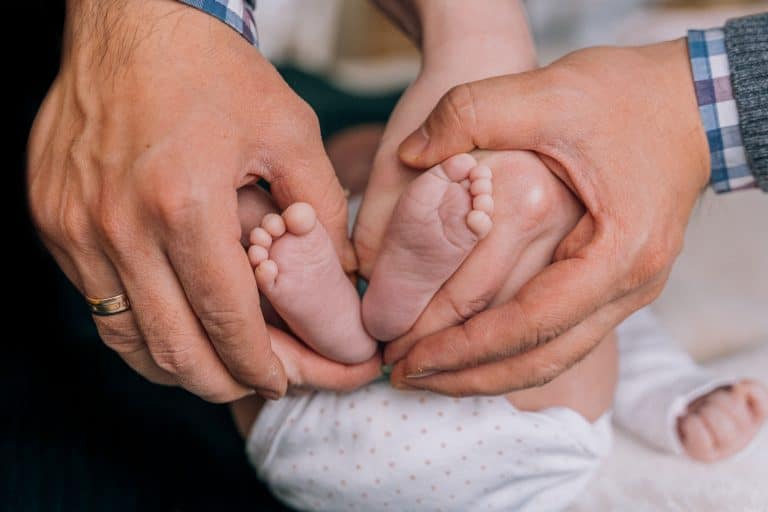 Parents massaging baby's feet